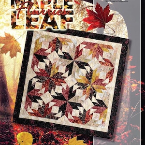 May include: A quilt with a geometric pattern in shades of red, cream, and black, featuring the text "Maple Leaf Flurries." The quilt is bordered with a black and cream design. The image also includes the text "Timeless Treasures" and "Quiltworx.com."