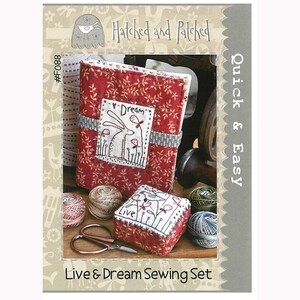 May include: A sewing kit with a red fabric box, a red fabric pincushion, and a pair of scissors. The box has a white rabbit with the word "Dream" above it. The pincushion has the word "Live" on it. The kit is labeled "Live & Dream Sewing Set" and "Quick & Easy".