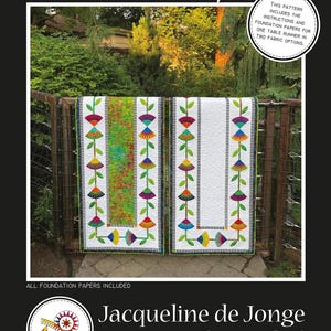 May include: Two table runners with floral designs hang on a fence. One runner has a white background with colorful flowers, the other has a green and red patterned center. Text includes "Miss Daisy" and "Jacqueline de Jonge BeColourful".