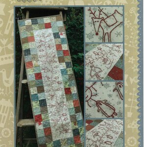 May include: A Christmas Garland Table Runner with a patchwork design. The runner features a central embroidered design with festive motifs and is displayed on a wooden ladder. The text "Hatched and Patched" is at the top.