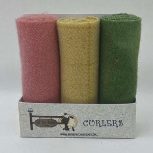 May include: Three rolls of wool yarn in pink, yellow, and green colors. The yarn is packaged in a cardboard box with the text "Curlers" and a website address.