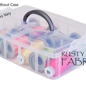 May include: A clear plastic storage box with a handle, filled with colorful spools of ribbon. The box has a label that says "Rusty Roof Fabrics".