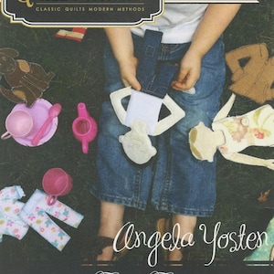 May include: A craft kit for making fusible flats dolls. The kit includes printed interfacing for dolls, pets, and clothes. The image shows a child holding a doll and accessories. The text on the kit reads "Quiltsmart" and "Angela Yosten".