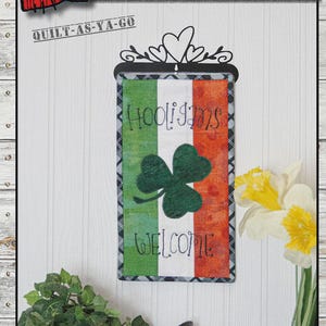 May include: A decorative wall hanging with the text "WELCOME HOOLIGANS" and a shamrock design. The sign is 6.5" x 12" and features the colors of the Irish flag. The words "WELCOME" and "HOOLIGANS" are stitched on the fabric.
