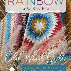 May include: A colorful quilt book cover with the title "Rainbow Scraps" and "Color Wheel Quilts." The book features a vibrant quilt with a starburst design in shades of blue, red, and gold. The text reads "20 Colorful Patterns Beginner to Expert Level."