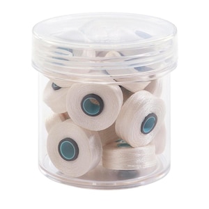May include: A clear plastic container filled with white thread spools. The spools have a blue and black center.