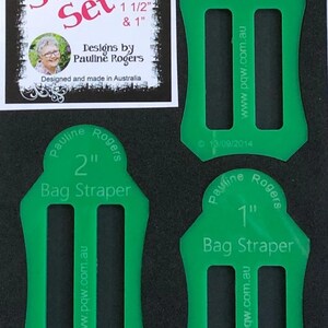 May include: A set of green plastic bag strapers in 1", 1 1/2", and 2" sizes. The set includes a label with the text "Straper Set" and "Designs by Pauline Rogers". The strapers are designed and made in Australia.