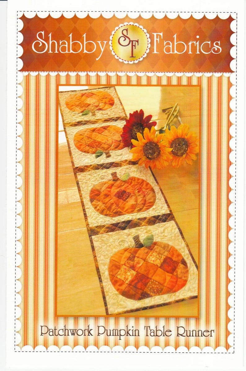 K&ouml;nnte beinhalten: Dekorativer Tischl&auml;ufer mit Patchwork-K&uuml;rbismotiven. Der L&auml;ufer hat einen cremefarbenen Hintergrund mit orangefarbenen und braunen K&uuml;rbisapplikationen. Der Text "Shabby Fabrics" und "Patchwork Pumpkin Table Runner" sind sichtbar.