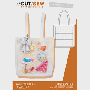 May include: A white tote bag with a variety of colorful embellishments, including a bow, star, and heart-shaped pins. The bag has a diagram of a tote bag on the right side. Text on the bag reads "//CUT/SEW PATTERNMAKING" and "ONE SIZE FITS ALL".
