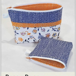 May include: Two Becca Bags with a blue and white dotted pattern, orange lining, and floral accents. The bags have zippers and are labeled "Lazy Girl Designs". The text "BECCA BAGS" is also visible.
