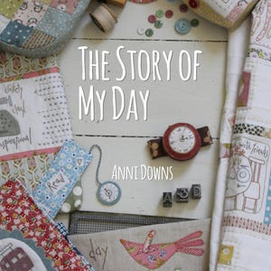 May include: A book cover with the title "The Story of My Day" by Anni Downs. The cover features a variety of colorful fabric scraps, including a red and white polka dot fabric, a blue and white floral fabric, and a green and white plaid fabric. The cover also features a small red clock, a small blue clock, and a small red bird.