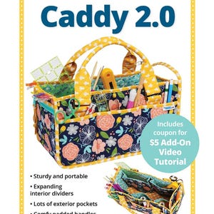 May include: A floral print Catch All Caddy 2.0 with yellow handles and trim, filled with sewing supplies. The caddy has exterior pockets and expanding interior dividers. The text reads "Catch All Caddy 2.0" and "Organize and carry all your supplies!"