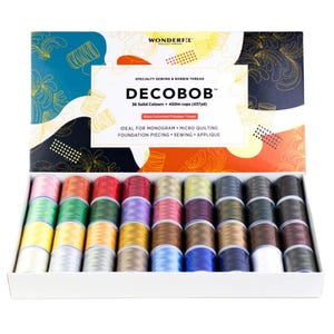 May include: A box of 36 spools of DecoBob thread, a specialty sewing and bobbin thread. The spools are arranged in rows and are all different colors. The box is white with a colorful design on the top. The text on the box reads "DecoBob 36 Solid Colors 400m cops (437yd)".