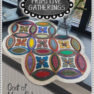 May include: A handcrafted, colorful textile piece with an oval and floral design. The text "PRIMITIVE GATHERINGS" is at the top, and "Coat of Many Colors" is at the bottom. Finished size is 18" x 27".