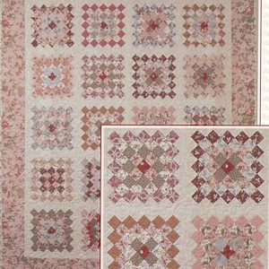 May include: A patchwork quilt with a floral border and a cream-colored center. The quilt features a repeating pattern of square blocks in shades of pink, red, and brown. The blocks are arranged in a grid-like pattern, creating a cozy and inviting aesthetic.
