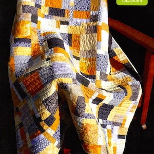 May include: A patchwork quilt draped over a wooden chair. The quilt features a geometric pattern in shades of yellow, orange, black, and white. The text "Lemon Pepper" is visible at the bottom. The Madison Cottage Design logo is in the top right corner.