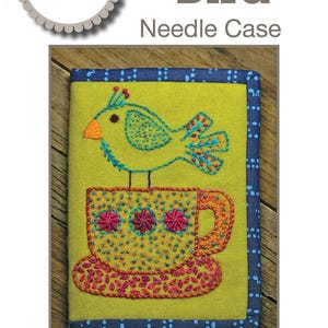 May include: A handmade needle case with a whimsical design. The cover features an embroidered bird perched on a teacup, with a yellow background and blue border. The closed size is 4" x 6". The text "Tea Bird Needle Case" is displayed.