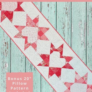 May include: A red and white Starlet Hearts table runner quilt pattern with star and heart designs. The pattern includes a bonus 20-inch pillow pattern. The finished table runner measures 19 inches by 69 inches.