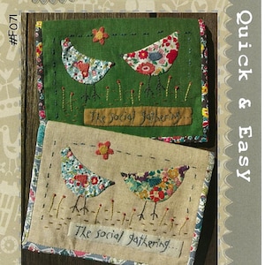May include: Two embroidered project pouches with bird and floral designs. One is green, the other beige. Each features two birds, a flower, and the text "The social gathering..." in a whimsical style. The pouches are labeled "Quick & Easy".