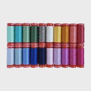 May include: A collection of colorful Aurifil cotton thread spools. The spools are arranged in rows, showcasing a variety of hues including teal, blue, green, and pink. Each spool has a red cap and is labeled with text.