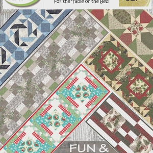 May include: A display of colorful fabric table runners with various patterns, including geometric shapes, floral designs, and holiday themes. The text reads "Big Block Runners" and "For the Table or the Bed."