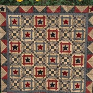 May include: A quilt featuring a repeating pattern of stars in red, blue, and black, set within tan and dark gray geometric blocks. The border consists of red and gray triangles. The text "Sew Cherished", "SCH269", and "Liberty Star" is visible.