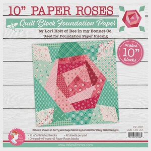 May include: Paper roses quilt block foundation paper by Lori Holt. The design features a large rose made of various pink and red fabrics, surrounded by green and white patterned fabric. The paper is designed to make 10-inch blocks.