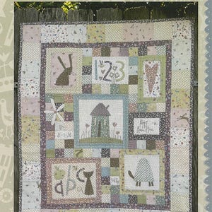 May include: A patchwork quilt featuring a central house illustration, surrounded by blocks depicting a rabbit, numbers 1-2-3, a heart, a cat with the letters abc, and a turtle. The quilt includes the text Hatched and Patched and Time to Daydream.