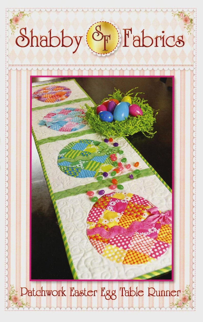 May include: A patchwork Easter egg table runner with colourful egg designs. The runner has a white background with green accents and a pink border. The image includes a nest with Easter eggs and scattered jelly beans. The text "Shabby Fabrics" and "Patchwork Easter Egg Table Runner" are visible.