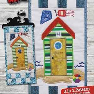 May include: A fabric panel with a beach hut design, featuring a green and white striped hut with a red roof, a yellow door, and a blue kite. The finished size is 6.5 x 12.25 inches. The text "BEACH HUT" is at the top.