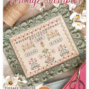 May include: A vintage sampler cross stitch pattern with a green frame, featuring the alphabet, numbers, and floral designs. The title "Vintage Sampler" is at the top of the image, and the text "Vintage Inspired" and "Designed by Lori Holt" are at the bottom. The text "Bee in my Bonnet Co." is also at the bottom of the image.
