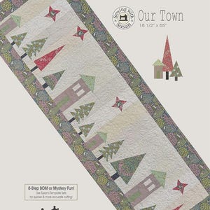 May include: A quilted table runner with a town scene design. The runner features houses, trees, and stars in shades of pink, green, and red, with a cream background. The runner measures 18.5 inches by 55 inches.