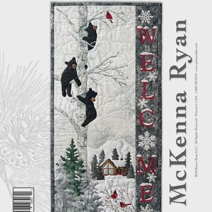 May include: A quilted wall hanging featuring a winter scene with black bears climbing a tree. The words "WELCOME" are embroidered vertically. The quilt measures 16" x 32". The text "Bear Foot Lodge" is at the top.