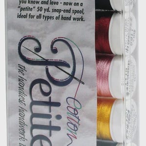 May include: A clear plastic package containing spools of Sulky Petites Cotton thread. The package displays the text "Petites" and "Cotton Kettler". The spools are in various colors, including black, red, pink, yellow, blue, and green. The text on the package reads "50 yds. Per Spool Machine Washable 100% Cotton 12 wt."