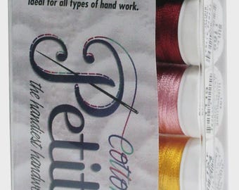 May include: A clear plastic package containing spools of Sulky Petites Cotton thread. The package displays the text "Petites" and "Cotton Kettler". The spools are in various colors, including black, red, pink, yellow, blue, and green. The text on the package reads "50 yds. Per Spool Machine Washable 100% Cotton 12 wt."