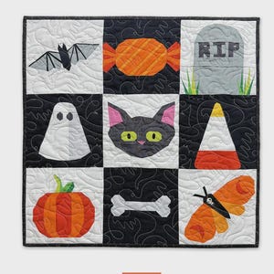 May include: A Halloween-themed quilt with nine squares, each featuring a different spooky design. Includes a bat, candy, tombstone, ghost, black cat, candy corn, pumpkin, bone, and moth. The text "Frightful Minis" and "a fun foundation paper-pieced wall hanging!" are visible.
