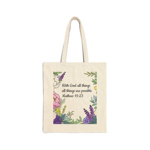 Könnte beinhalten: Cremefarbene Tragetasche mit floralem Design und dem Text "With God all things are possible Mathew 19:23". Das florale Design umfasst rosa, lila und gelbe Blumen mit grünen Blättern. Die Tasche hat zwei cremefarbene Griffe.