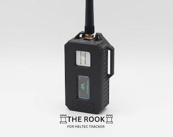Op de afbeelding: Een zwart draagbaar apparaat met een klein scherm en een antenne. Het scherm toont de tekst "mechatec.org" en een groene pijl. Het apparaat heeft een label met de tekst "Wireless Tracker 003314000". Het apparaat is gelabeld met "THE ROOK FOR HELTEC TRACKER".