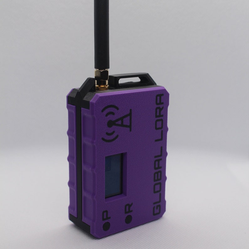May include: A purple Global Lora device with a black antenna, a small screen, and two buttons labeled "ON" and "OR".