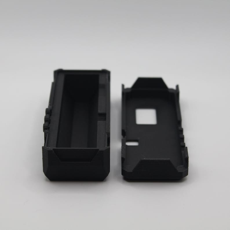 May include: Two black plastic rectangular cases, one open and one closed. The open case has a rectangular cavity inside.