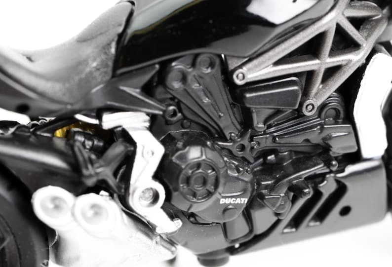 May include: Close-up of a black Ducati motorcycle engine. The engine features intricate details, including silver accents, a visible Ducati logo, and various mechanical components. The image highlights the motorcycle's design and engineering.