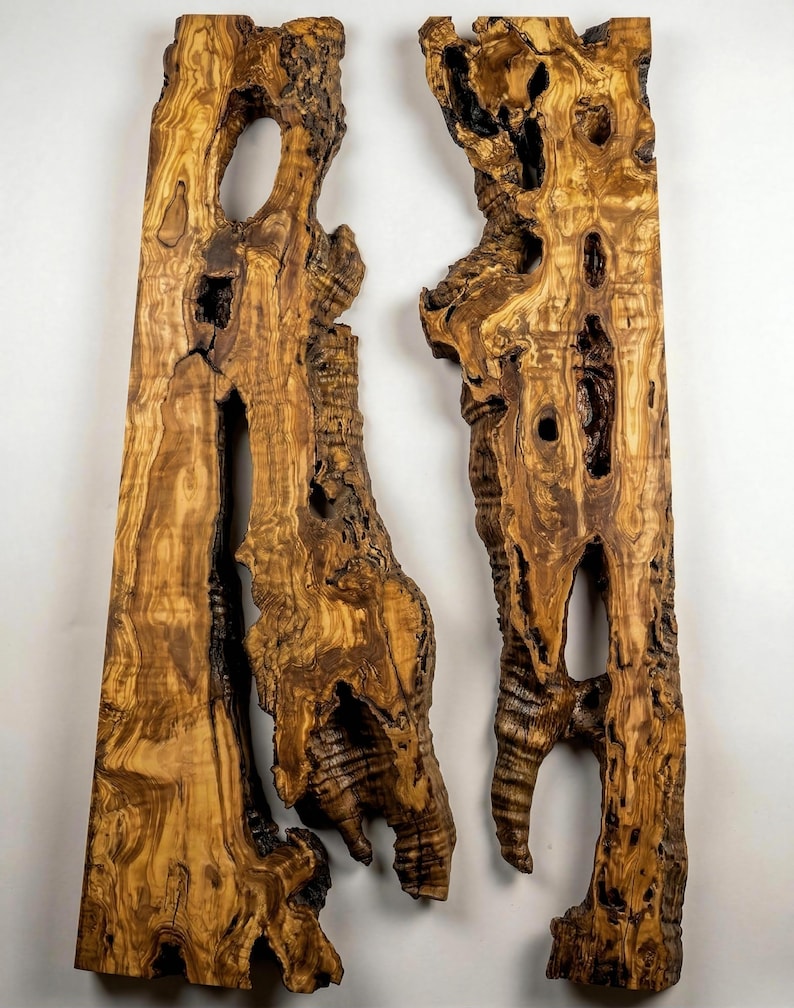 May include: Two vertical wooden slabs with irregular edges and natural holes. The wood has a warm, brown color with darker streaks and patterns, suggesting a natural grain. The slabs are likely for decorative or functional use.