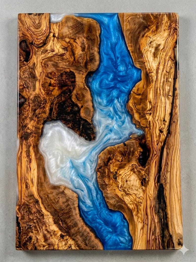 May include: A rectangular wooden art piece with a river-like design. The wood has a natural, warm brown color with intricate grain patterns. The river is made of blue and white resin, creating a flowing, water-like effect.