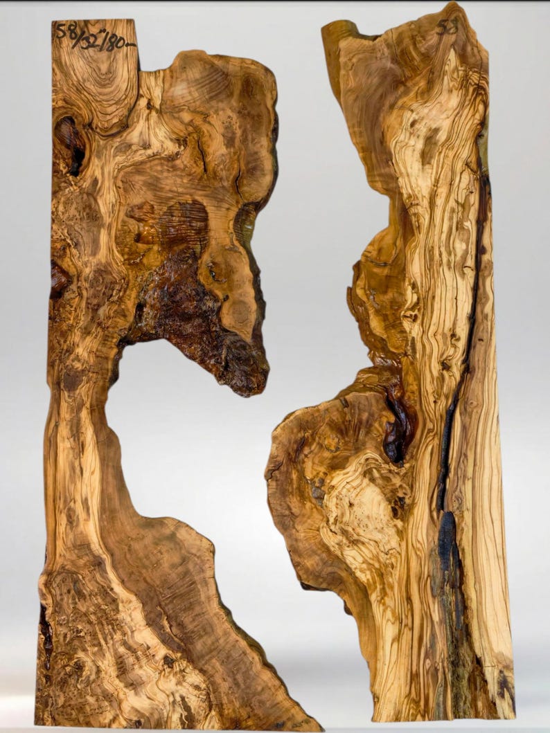 May include: Two irregularly shaped wooden slabs with a natural, organic aesthetic. The wood grain is prominent, showcasing a mix of light and dark brown tones. The slabs have a unique, open design with a cutout in the center. The text "58/52/180" is visible.