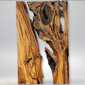 May include: A two-piece wooden wall art piece with a natural, organic design. The wood features rich brown and tan tones with dark, contrasting knots and grain patterns. The pieces are separated by a white space, and the bottom left corner has the text "10/16".