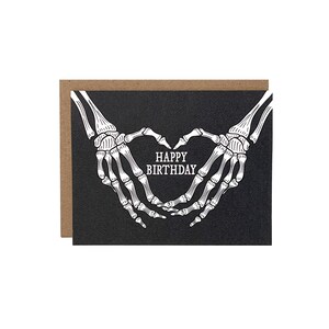 Cartão de feliz aniversário com mãos de esqueleto gótico e coração, cartão de aniversário gótico
