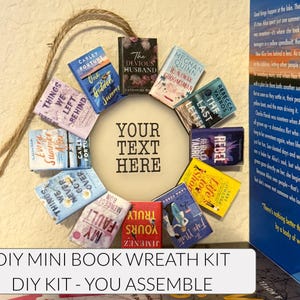 May include: A DIY mini book wreath kit with miniature book covers arranged in a circular design. The wreath includes a jute rope for hanging and a central circle with the text "YOUR TEXT HERE". The text "DIY MINI BOOK WREATH KIT" is displayed below.