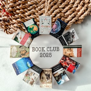 May include: A circular book club ornament featuring miniature book covers arranged around a white circle. The text "BOOK CLUB 2025" is printed in black. The ornament is set against a woven background with red berries.