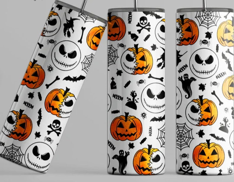 May include: A white tumbler with a Halloween themed design featuring Jack Skellington from The Nightmare Before Christmas, pumpkins, bats, spiders, and candy corn.
