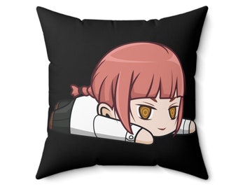 May include: Black square cushion featuring a cartoon illustration of a character with pink hair and yellow eyes. The character is lying down, wearing a white shirt and black trousers. The cushion is a decorative item.